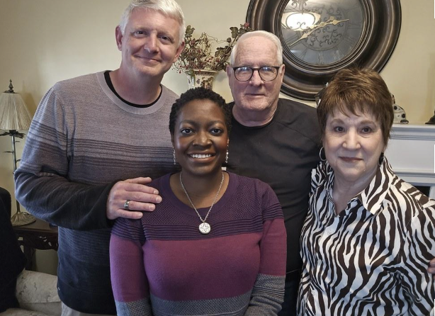 Mike and Nancy Bryan with Adam and Samantha Proehl, owners of Foothills Carpet Care, standing together in a warm home setting